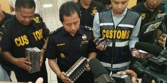 Petugas Bea Cukai memeriksa tumpukan rokok ilegal